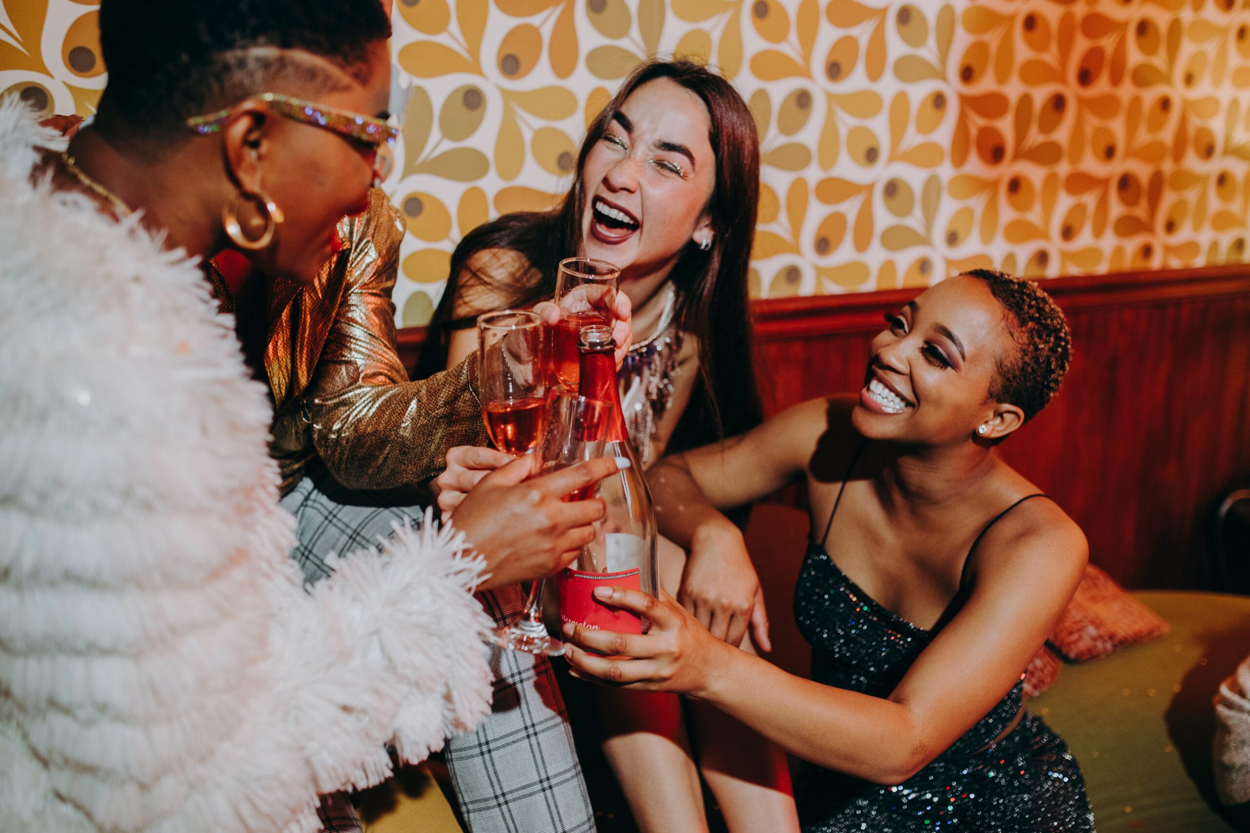 three women celebrating with glasses raised at a party Her life magnified